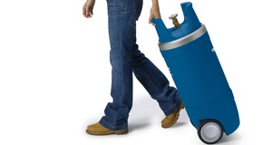 Woman with large blue generic Linde branded GENIE® gas cylinder with wheel base attached